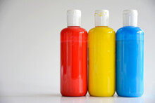 Red, Yellow, Blue Bottles On Gray Background