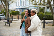 © Westend61 - Cheerful lesbian couple wearing jacket standing together on footpath