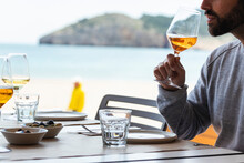 Young Man Drinking Wine At Beach Restaurant