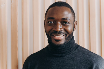 Portrait of happy cheerful african american man smiling at camera, expressing positive emotions