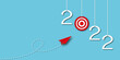 © Chitraporn - Red arrow hitting to red target centre in the year 2022 on blue background aas metaphor for business target or goal success and winner, success concepts, space for the text, paper art design style.
