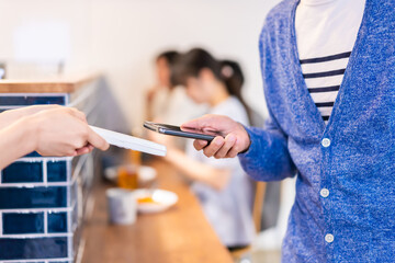 Poster - 飲食店で電子マネー決済をする男性