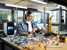 Smiling Female Engineer Working With Electrical Component In Industry