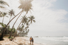Rear View Of Romantic Couple Walking On Sea Shore At Beach Against Sky, Sri Lanka