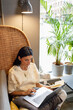 © Johnér - Young woman using laptop in cafe