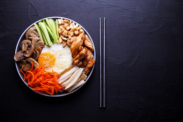 Bibimbap is a traditional dish of Korean cuisine on a dark background