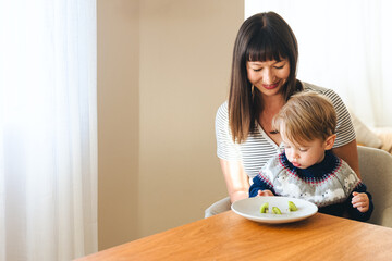 Wall Mural - Mother With Son Having Kiwi Fruit At Home