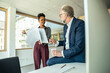 © Westend61 - Businessman talking to female colleague holding documents at office