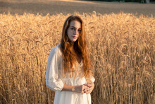 Redhead Woman With Wheat Plant Standing On Field