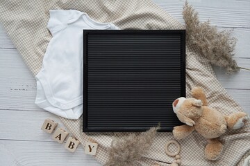 Black letterboard mockup, baby bodysuit, toys, pampas grass, blanket, pregnancy announcement, baby waiting.