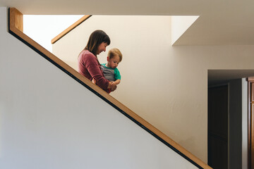 Wall Mural - Mother Carrying Son On Stairs In Home