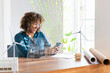 © Westend61 - Businesswoman using mobile phone by futuristic device screen and network connection in office