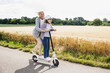 © Westend61 - Happy granddaughter and grandmother playing while riding push scooter during sunny day