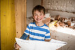 © Westend61 - Smiling boy holding blueprint while standing at loft apartment
