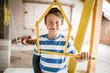 © Westend61 - Smiling boy holding pocket rule of house shape at attic