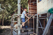 © Westend61 - Boy standing in wooden rabbit hutch at back yard