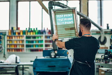 Wall Mural - Male worker preparing screen printing film in a workshop