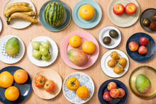 Top View Image Of Plate With Assorted Fruits, Watermelon, Grapefruit, African Mangoes, Ripe Avocados, Pink Tomatoes, Pears And Bananas, Apples, Persimmons