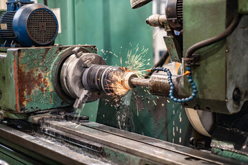 Wall Mural - High-precision machining of the metal of the outer surface on a grinding machine with flying sparks and water cooling