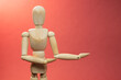 © Алексей Лымарчук - Wooden mannequin holding something, picture with free space to add your material, picture on red background
