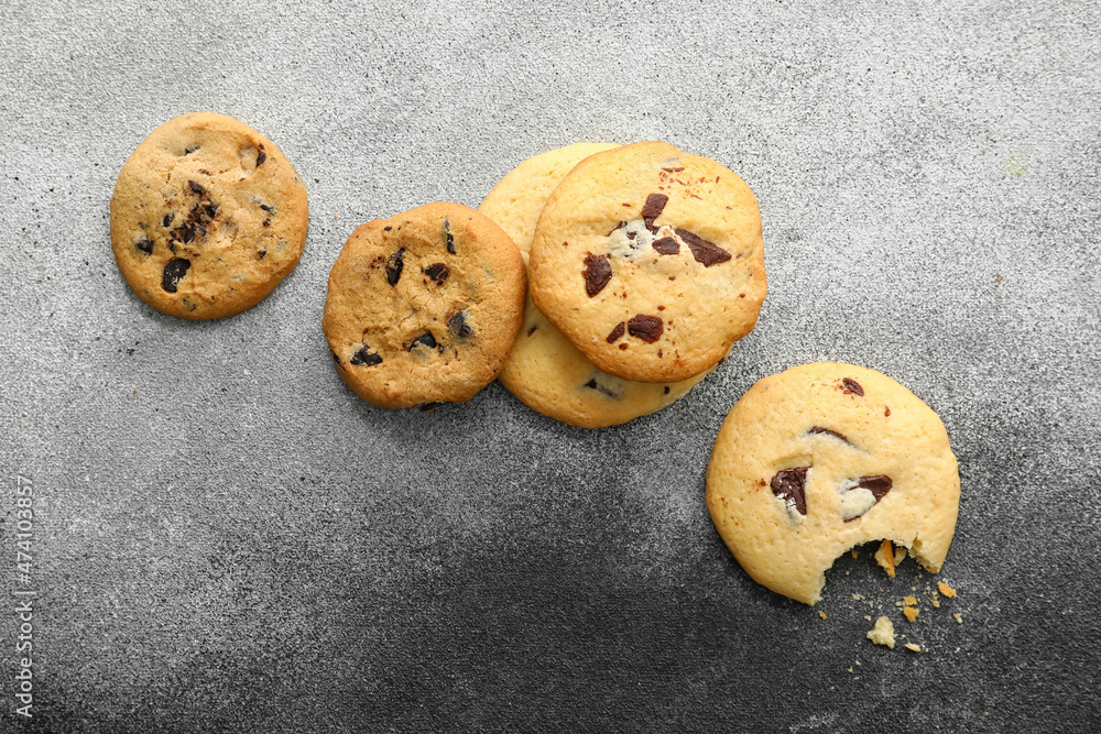Tasty homemade cookies with chocolate chips on grey background
