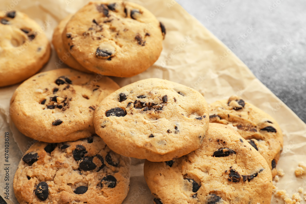 Parchment with tasty homemade cookies on table, closeup
