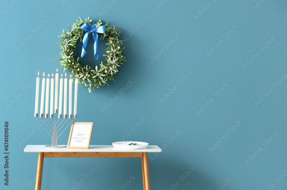 Menorah on table in room decorated for Hanukkah celebration