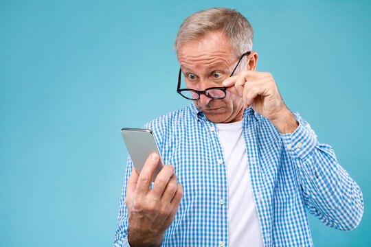 Surprised mature man using mobile phone, looking at screen