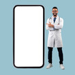 © Prostock-studio - Doctor pointing at big white empty smartphone screen, mock-up