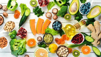 Wall Mural - Food background: fruits, vegetables and berries on a white wooden background. Top view. Rustic style.