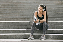 After Successful Workout. Young Korean Woman Resting On Steps Outdoors, Listening Music