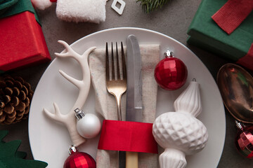 Wall Mural - Festive Christmas meal background. Place setting with plate and cutlery surrounded by decorations decorations