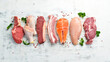 Set of raw meat steaks salmon, beef and chicken on a white wooden background. Top view.