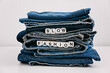 Slow fashion, second hand, Vintage Shopping, slow fashion, Sustainable fashion concept. Stack of blue old denim jeans with the words slow fashion