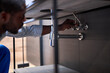 © alfa27 - Afro american professional Plumber working in bathroom at home, skilled confident handyman plumbing repair service, repairing. assemble and install concept. side view portrait.