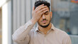 © Yuliia - Male portrait outdoors in city young ethnic hispanic latin bearded guy sad upset frustrated stressful in desperate business man looking at camera close face with hand palm lost loosing problem concept