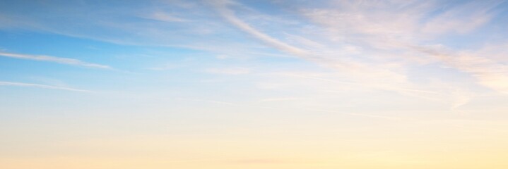 Clear blue sky. glowing pink and golden cirrus and cumulus clouds after storm, soft sunlight. Dramatic sunset cloudscape. Meteorology, heaven, peace, graphic resources, picturesque panoramic scenery