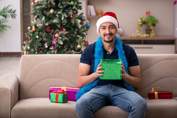 Wall Mural - Young man celebrating Christmas at home