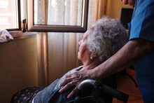 Anonymous Nurse With Disabled Aged Woman Near Window
