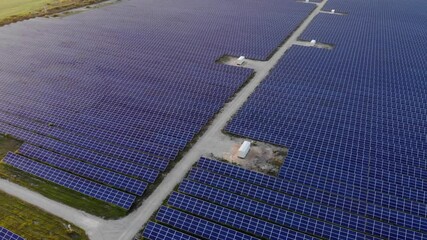 Wall Mural - Alternative energy. Aerial view of solar farm. Drone flies over rows of solar panels at sunset.