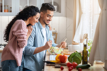 Cooking Together. Happy millennial middle eastern couple preparing food in kitchen