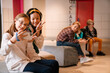 © Drobot Dean - Multiracial girls gesturing peace sign while taking selfie on cellphone