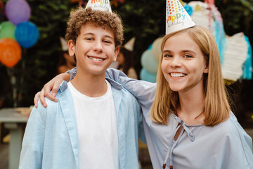 White girl and boy smiling and hugging during birthday party