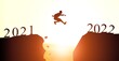 © BillionPhotos.com - Welcome merry Christmas and happy new year in 2022,Silhouette Man jumping from cliff