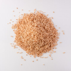 Wall Mural - pile of whole grain brown rice isolated on white background, closeup view taken from above