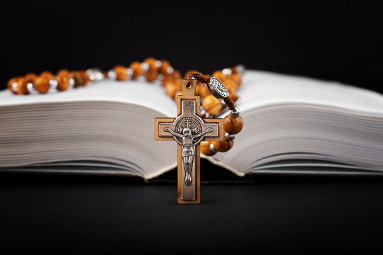 Traditional christian holy religious wooden rosary  with bible on black background