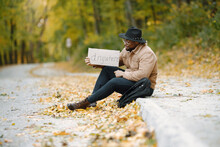 Black Man Hitchhiking On A Road And Holding A Sign Anywhere