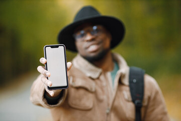 Portrait of black man traveler showing blank copy screen cell phone