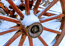 An Old Antique Faded Red Wooden Spoked Wagon Wheel With A Light Covering Of Snow From Last Nights Snowfall, Here In Upstate NY> 