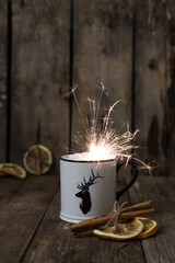 Wall Mural - Mug with a drink with a deer and bingala fire on a wooden background